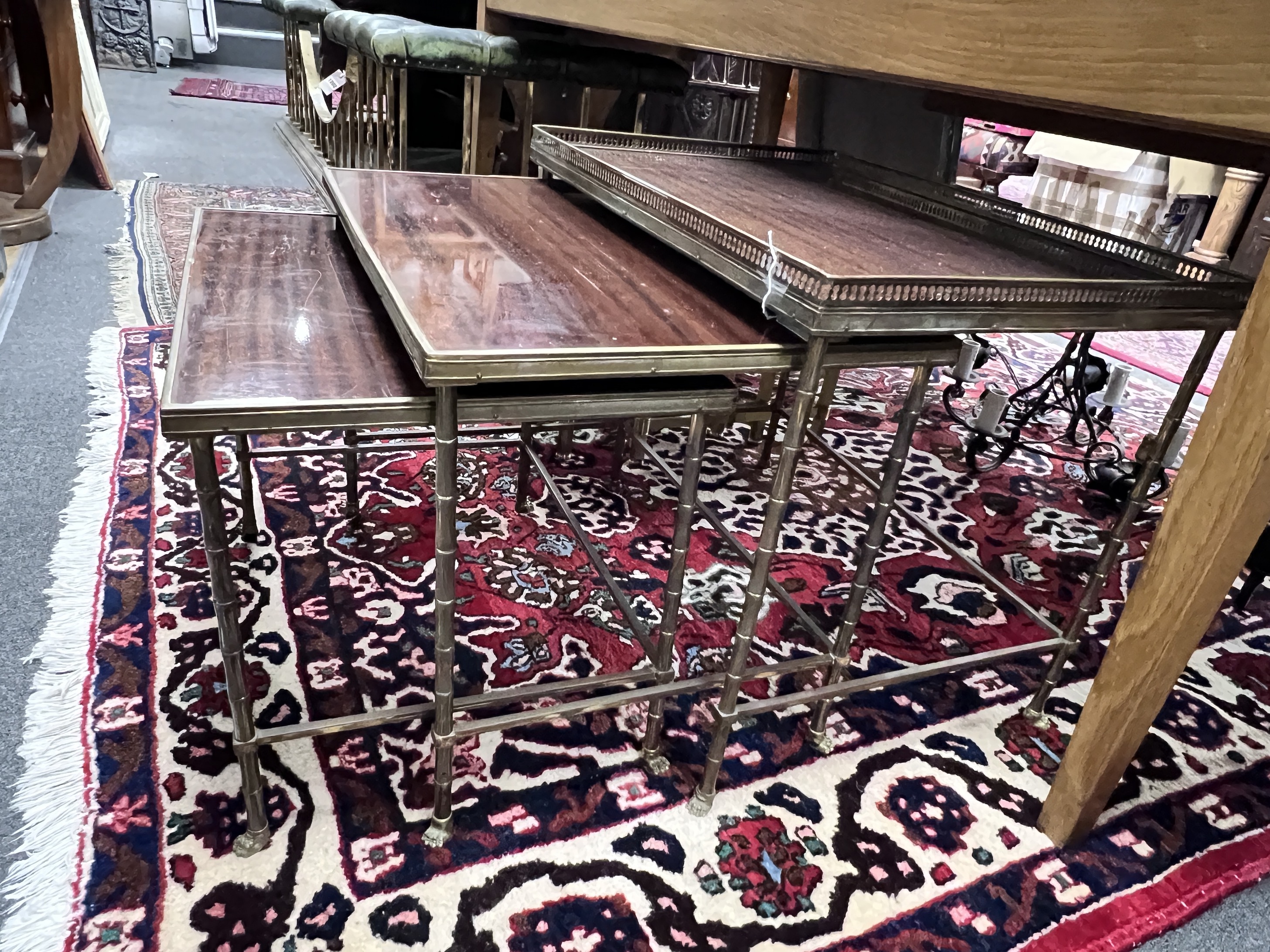 A nest of three graduated brass and mahogany faux bamboo 'Maison Charles' style tables, largest width 60cm